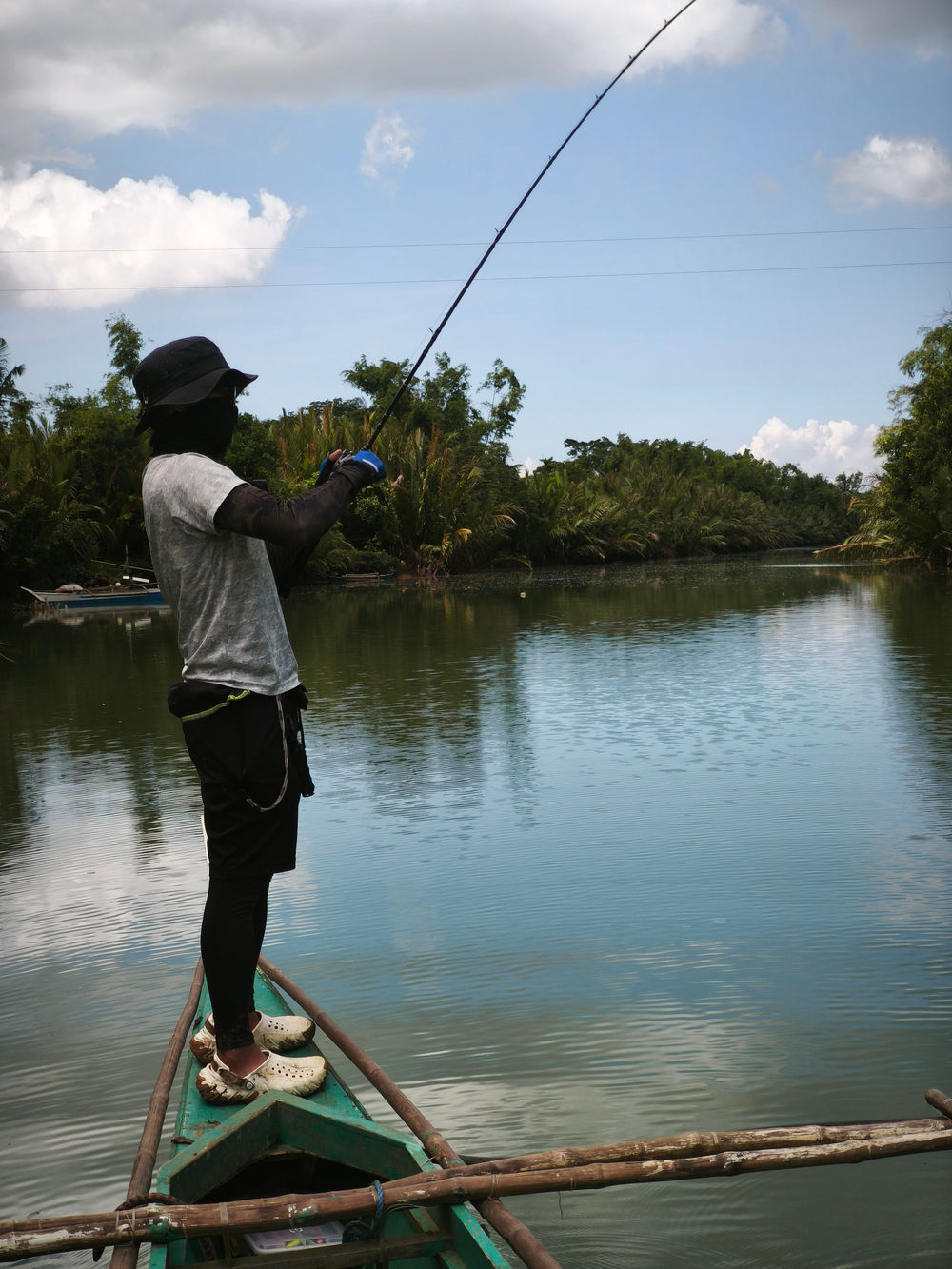 Angler casting from the bow of a small boat